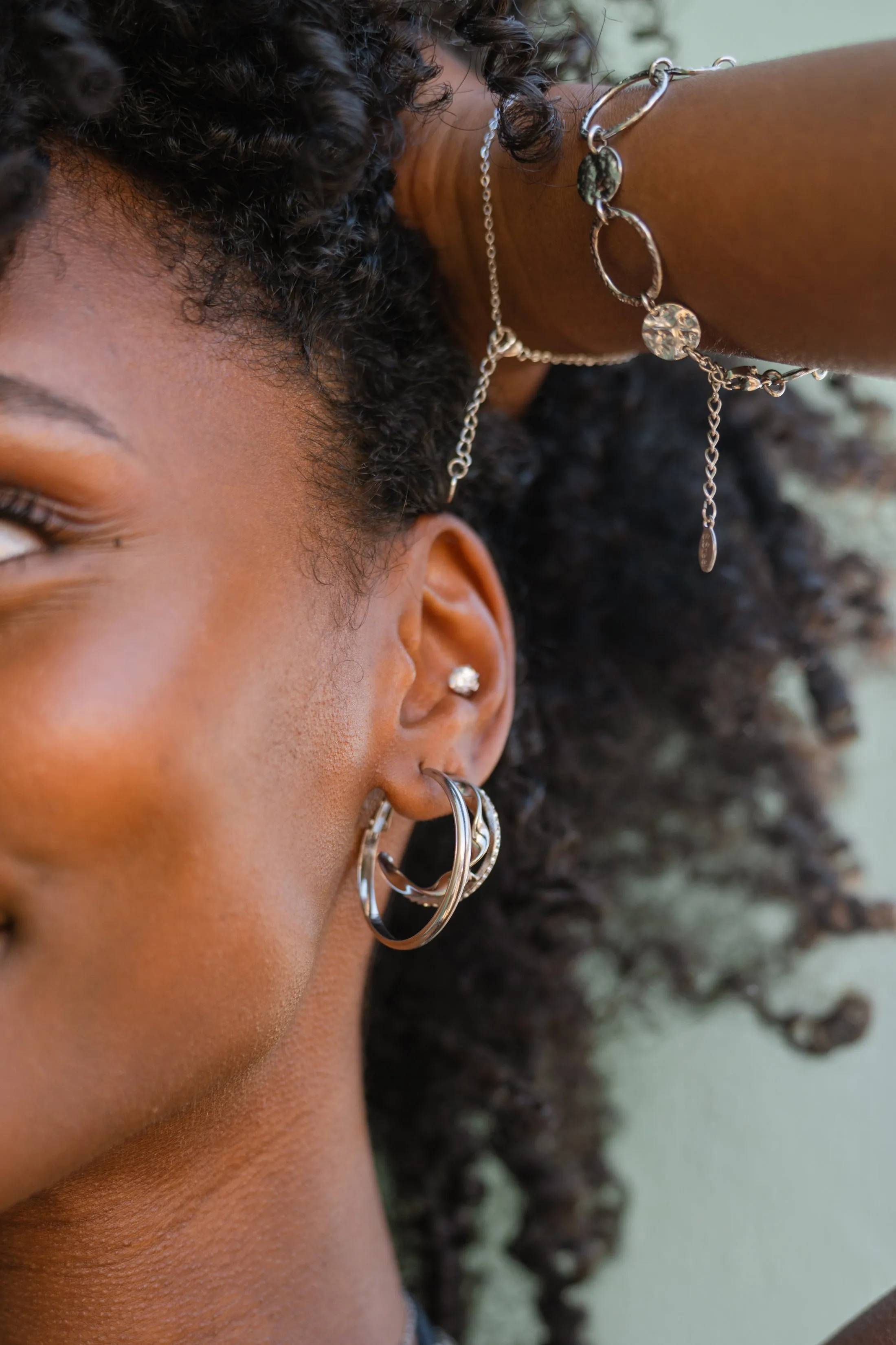 Accumulation de créoles en argent et puce d'oreille portées sur cheveux bouclés relevés, shooting Mary Jane à Marseille