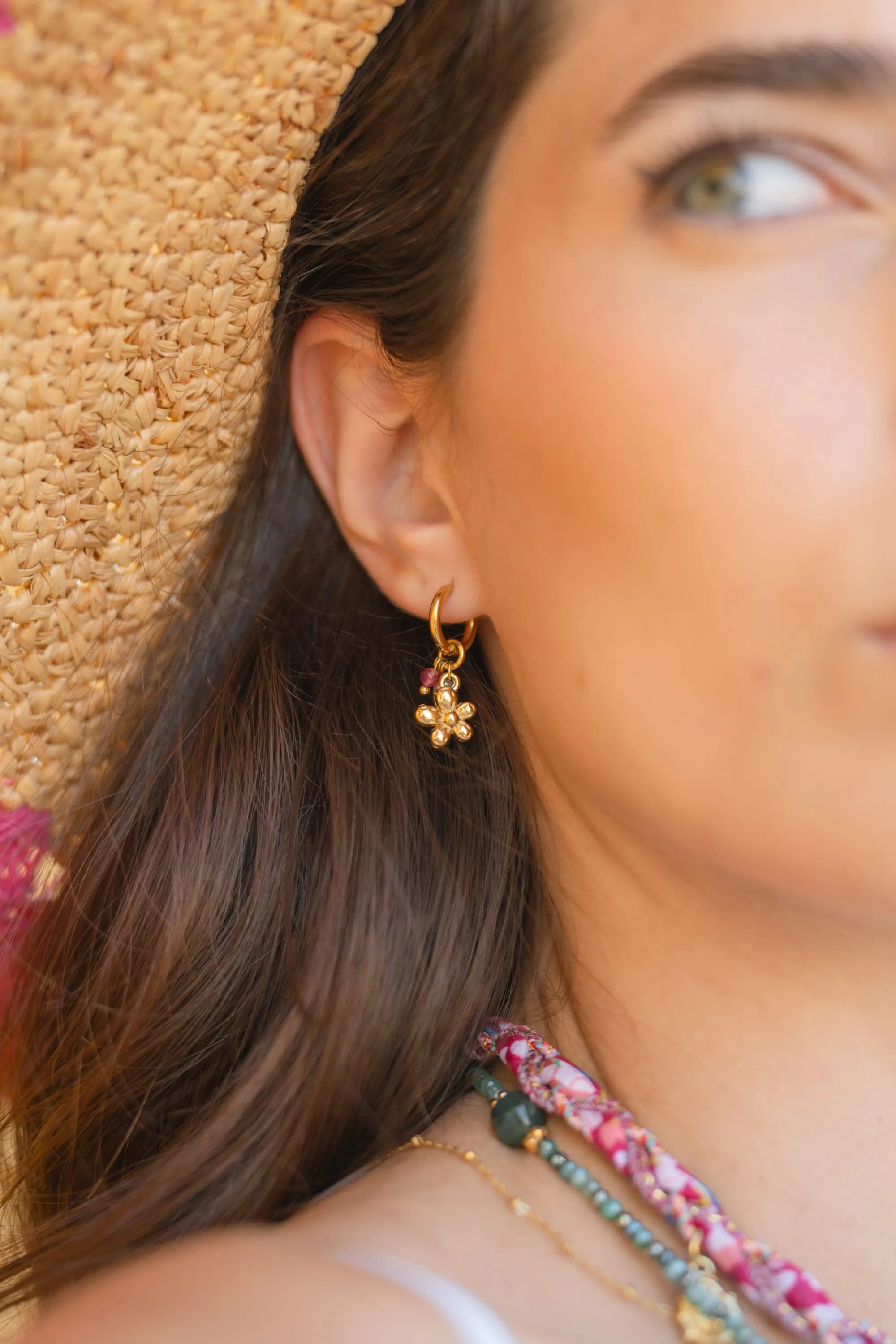Boucle d'oreille dorée portée, photographiée en gros plan lors du shooting Mary Jane