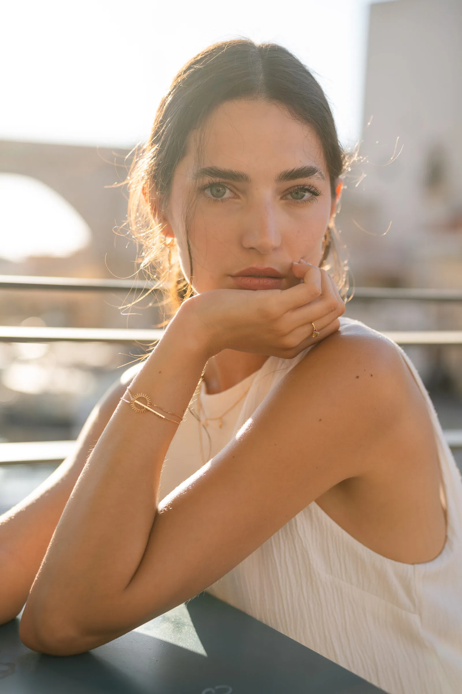 Bracelet doré porté en terrasse, lumière dorée, shooting Mary Jane à Marseille